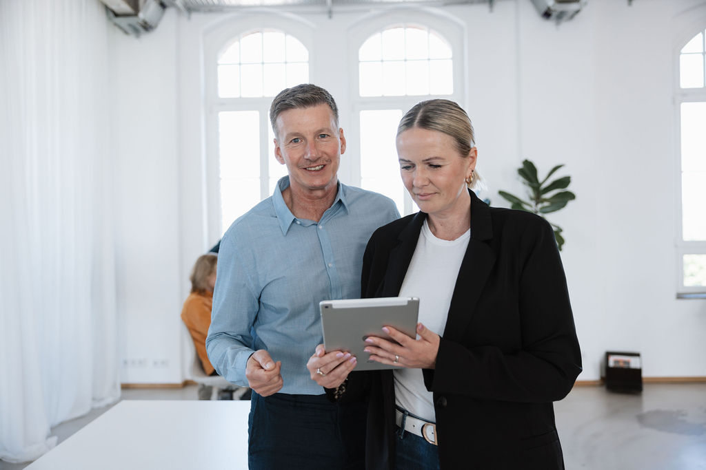 Mitarbeitende von LAN beraten Kundinnen und Kunden und schauen gemeinsam auf ein Tablet.