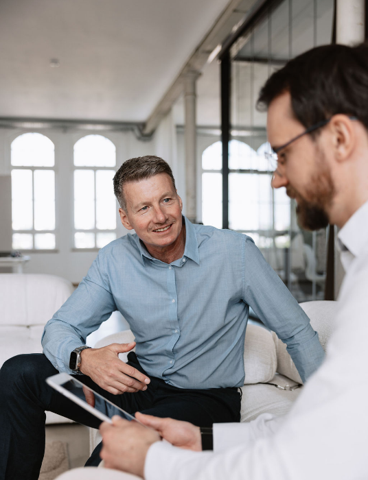 Zwei Männer besprechen Planungs- und Organisationsaufgaben in einem Büro.